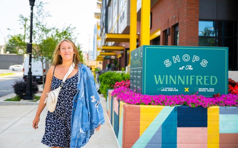 a woman standing next to a sign