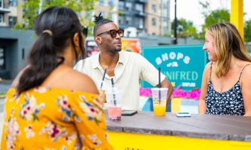 three people sitting down with drinks